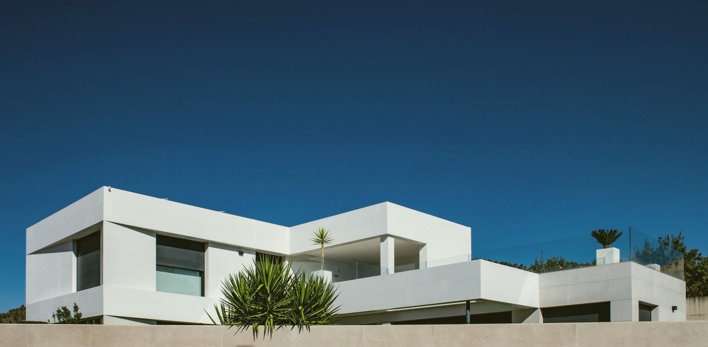 A modern white house under a deep blue sky